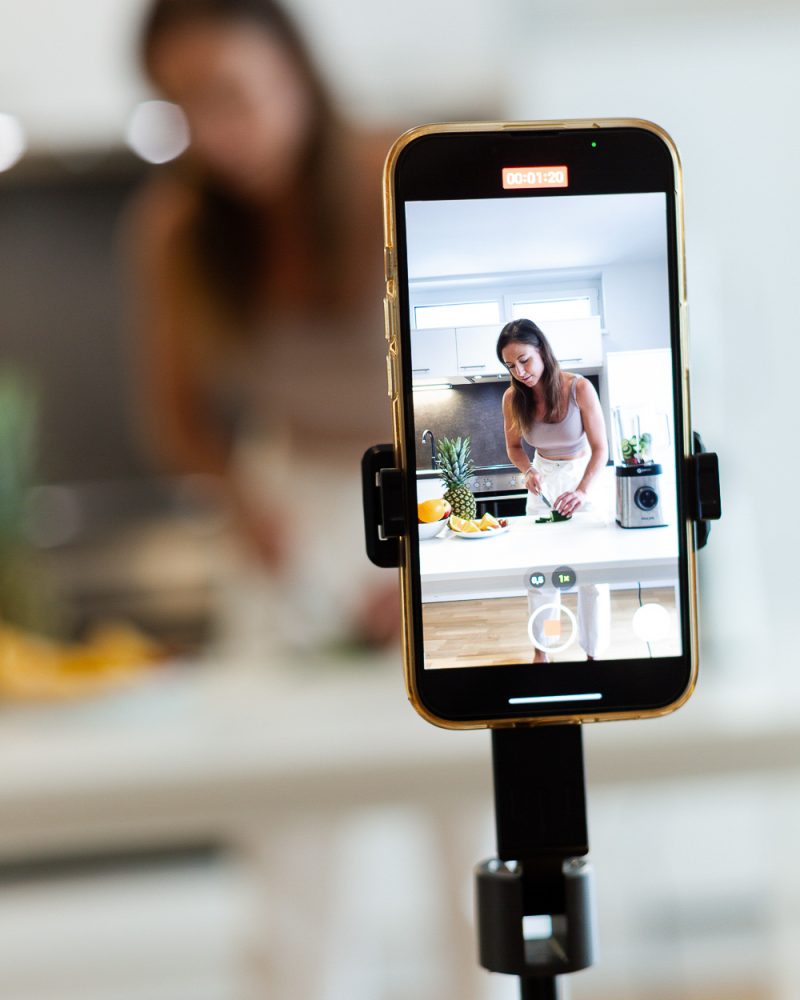 Smartphone im Vordergrund, Ernährungscoach im Hintergrund verschwommen.